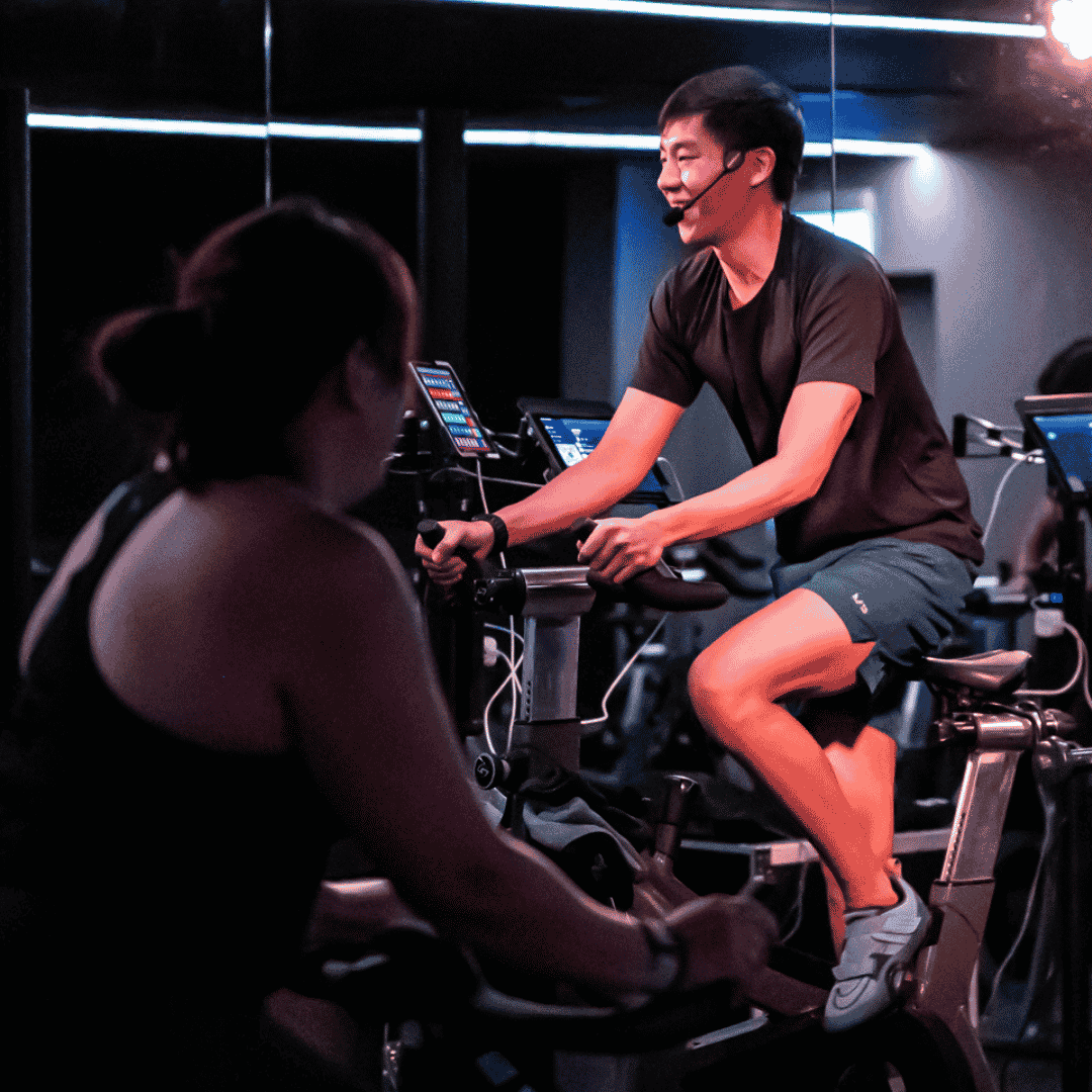 Spin class at SALT Fitness with riders in a dark studi