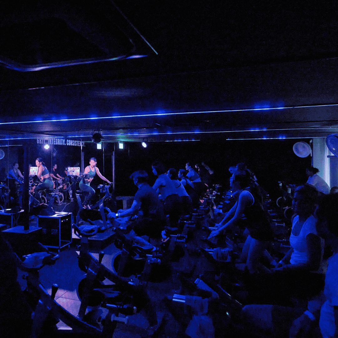 Spin class at SALT Fitness Singapore with riders in rhythm-based indoor cycling session